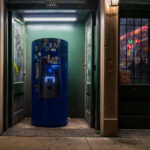 A blue ATM sits in a narrow doorway at 211 Decatur Street in New Orleans, surrounded by graffiti and stickers. T