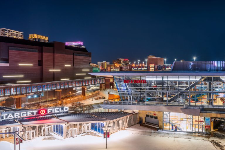 Target Field and Bat & Barrel on a Snowy Night in Minneapolis 3 Target Field stadium and surrounding downtown Minneapolis buildings illuminated at night with snow on the ground.