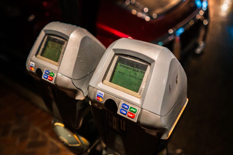 Electronic Parking Meters, New Orleans 2 Two vintage parking meters with green LCD displays and illuminated button panels at night.
