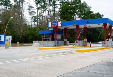 Nestled in the woods of Hancock County, Mississippi, the Stennis Space Center has been a cornerstone of NASA’s propulsion testing since the 1960s. The security gate, painted in the agency’s signature red, white, and blue, greets all who enter the sprawling complex where engines for Apollo, the Space Shuttle, and today’s Artemis missions have been put through their paces. The unassuming roadside checkpoint belies the scale of the technological achievements within, underscoring how a quiet patch of southern forest became central to America’s spaceflight history.