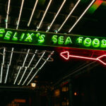 A neon sign glows above the entrance to Felix’s Sea Foods.  The restaurant is a well-known spot in New Orleans’ French Quarter, recognized for its oysters and casual seafood dining.