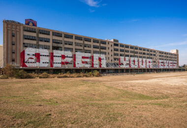 Large-scale graffiti covers the façade of a decommissioned warehouse at the former Naval Support Activity base in New Orleans, Louisiana. Once part of a sprawling military logistics hub along the Mississippi River, the site has since become an unofficial canvas for artists and taggers. The “Open House” mural stretches across multiple bays of the building, symbolizing both abandonment and transformation as the complex awaits redevelopment under civic revitalization plans.