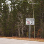Along a quiet stretch of pine-lined Highway 607 in Hancock County, Mississippi, a sign alerts motorists: Now Entering NASA/SSC Security Enforcement Area. Beyond this point lies the vast Stennis Space Center, where engines for Apollo, the Space Shuttle, and Artemis have been tested at full throttle. The reminder of security restrictions — paired with the speed limit notice — reflects how an otherwise ordinary southern highway doubles as the gateway to one of the most advanced propulsion test facilities in the world.