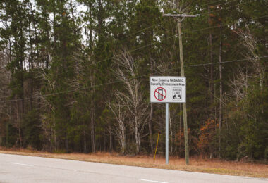 Along a quiet stretch of pine-lined Highway 607 in Hancock County, Mississippi, a sign alerts motorists: Now Entering NASA/SSC Security Enforcement Area. Beyond this point lies the vast Stennis Space Center, where engines for Apollo, the Space Shuttle, and Artemis have been tested at full throttle. The reminder of security restrictions — paired with the speed limit notice — reflects how an otherwise ordinary southern highway doubles as the gateway to one of the most advanced propulsion test facilities in the world.