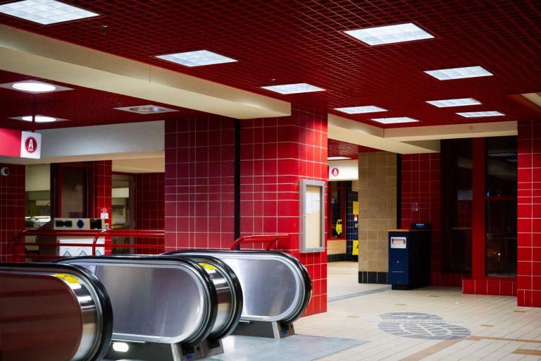 Ramp A Skyway Escalators, Downtown Minneapolis 2 Red-tiled escalator station interior with metal escalators and illuminated ceiling panels in downtown Minneapolis.
