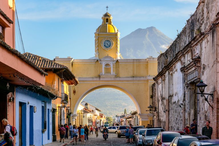 Santa Catalina Arch and Volcán de Agua, Antigua Guatemala 1 Santa Catalina Arch with its yellow clock tower frames a cobblestone street in colonial Antigua Guatemala, with Volcán de Agua rising in the background.