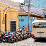 Woman carrying bread in Antigua, Guatemala and a bunch of motor bikes.