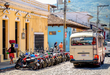 Woman carrying bread in Antigua, Guatemala and a bunch of motor bikes.