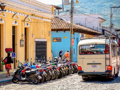 Antigua Guatemala street with bread seller and parked motorcycles