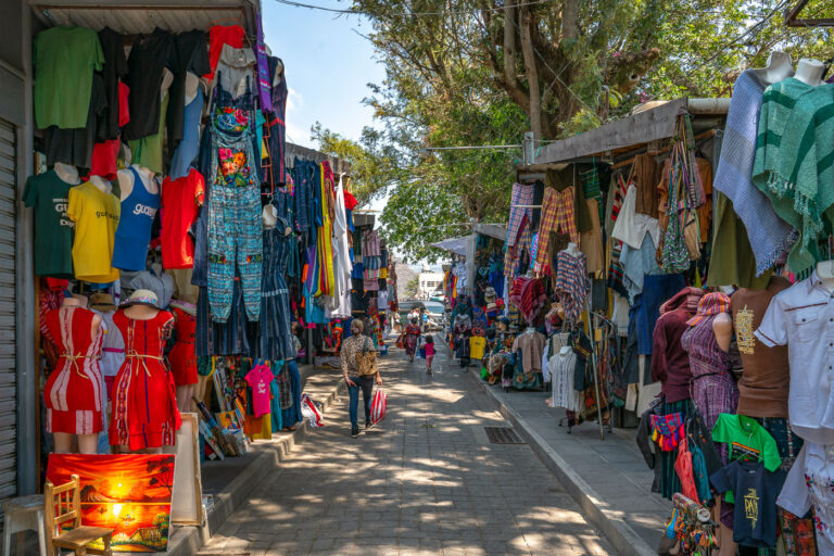 Panajachel Market: Mayan Textiles and Street Vendors 1 The bustling market in Panajachel, Guatemala, offers a vibrant display of traditional Mayan textiles and crafts. Street vendors line the pathways, showcasing a variety of woven goods, clothing, and souvenirs that reflect the rich cultural heritage of the region. These markets serve as vital economic hubs for local artisans and communities, providing a platform to sell their handcrafted items to both residents and tourists. The colorful textiles, often featuring intricate patterns and designs passed down through generations, are a significant aspect of Guatemalan identity and artistry.