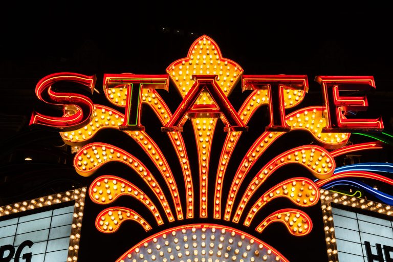 State Theatre Marquee on Hennepin Avenue in Minneapolis 2 Illuminated State Theatre marquee sign glows red and gold above the downtown Minneapolis theater entrance at night.