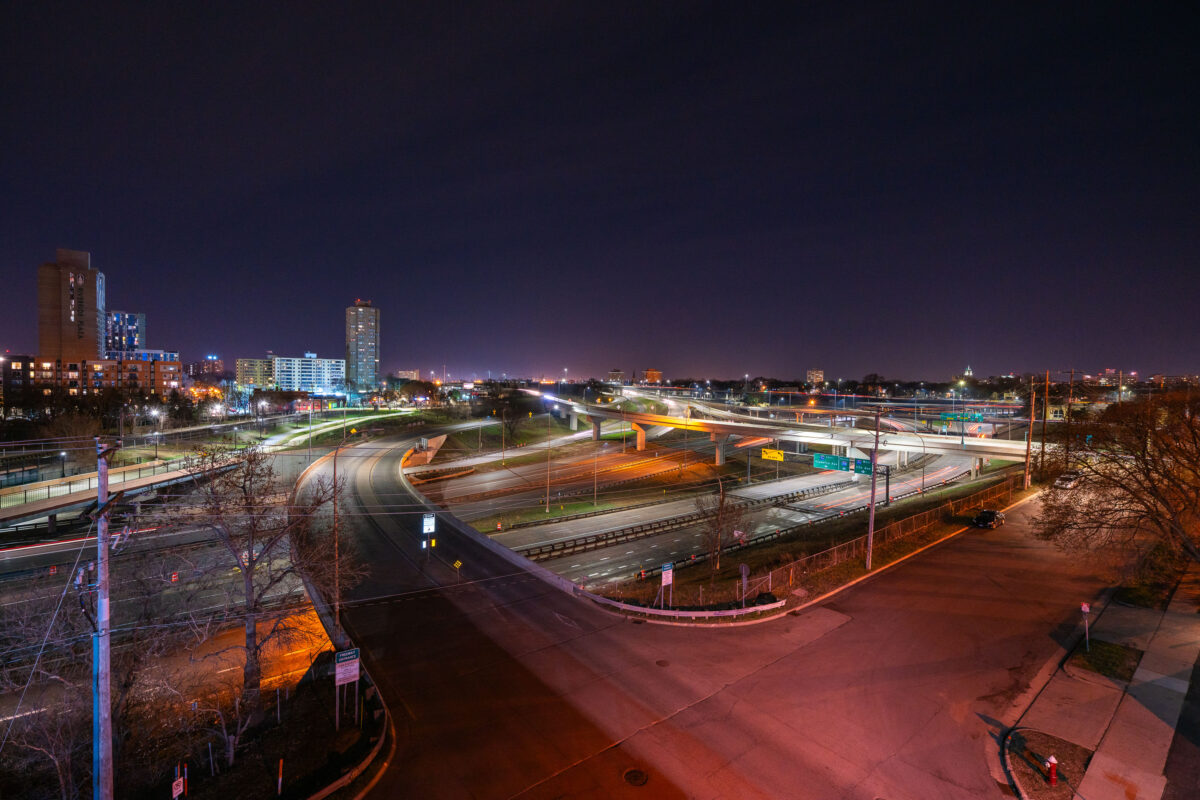Interstate 35W interchange in Minneapolis at night, with Riverside Plaza and light traffic.