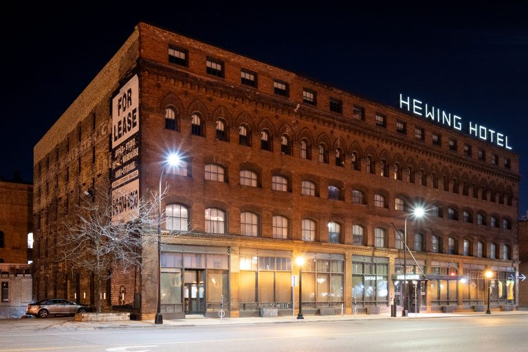 Hewing Hotel on Washington Avenue North in Minneapolis 1 Hewing Hotel, a historic brick building in Minneapolis's North Loop neighborhood, illuminated at night.