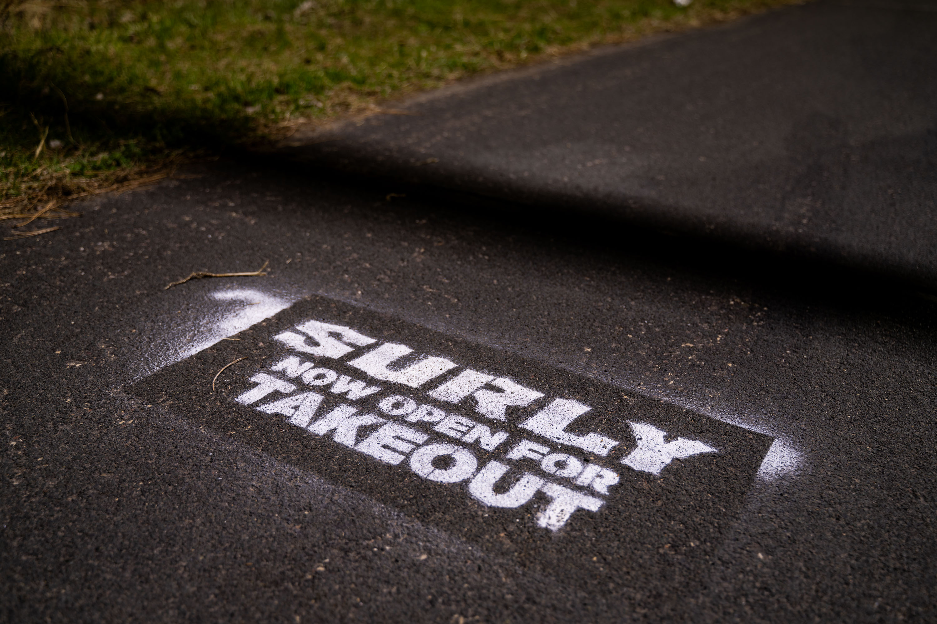 Surly beer brand stencil painted on asphalt in Prospect Park, Minneapolis.