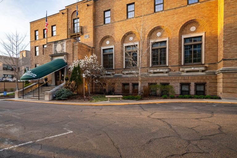 The Woman's Club Building on Oak Grove Street 2 The Women's Club, a brick Romanesque Revival building in downtown Minneapolis, features arched windows and an American flag.