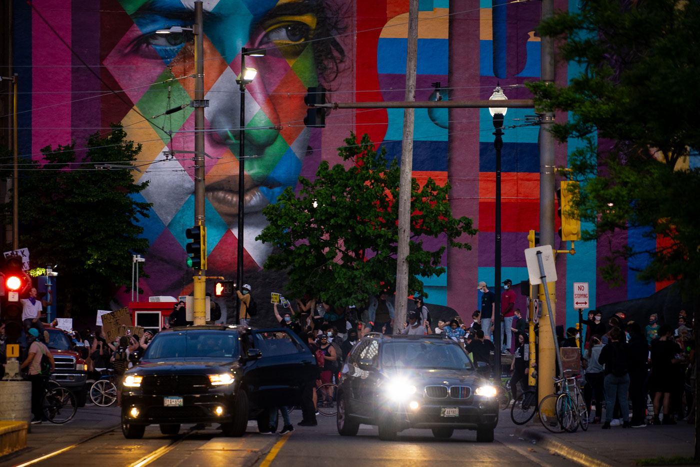 Bob Dylan mural with large group of protesters in front of it