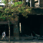 People walk by the burned out Foot Locker store on May 31, 2020 after it was burned in fires following the death of George Floyd.