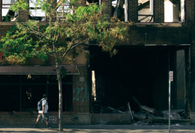 People walk by the burned out Foot Locker store on May 31, 2020 after it was burned in fires following the death of George Floyd.