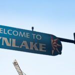 A burned "Welcome to Lynlake" sign on Lake Street and Lyndale Avenue on May 30, 2020. The sign was burned from dumpsters on fire below it after the murder of George Floyd.