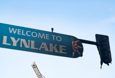 A burned "Welcome to Lynlake" sign on Lake Street and Lyndale Avenue on May 30, 2020. The sign was burned from dumpsters on fire below it after the murder of George Floyd.
