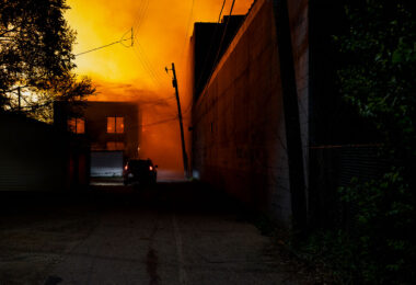 A car drives down an alley filled with smoke from fires on the 2nd day of protests in Minneapolis following the death of George Floyd.
