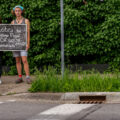 A couple hold up a sign that reads “Justice for George Floyd” on 36th St while others began to gather at the intersection of 38th St and Chicago Ave where Floyd was killed the night before.