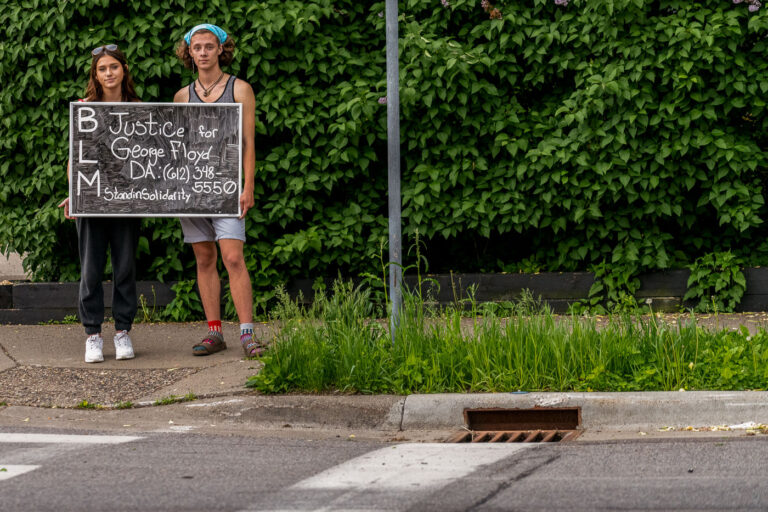 Protesters holding a protest sign on 36th St 3 A couple hold up a sign that reads “Justice for George Floyd” on 36th St while others began to gather at the intersection of 38th St and Chicago Ave where Floyd was killed the night before.