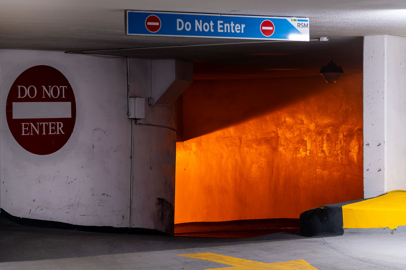 Do Not Enter signs and orange light in parking ramp