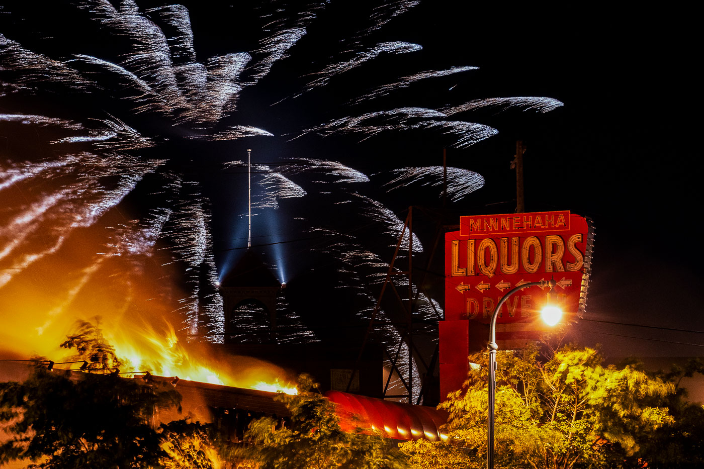 Fireworks explode above Minnehaha Liquor on Lake Street during the 3rd day of protests in Minneapolis following the death of George Floyd.