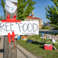 Sign that reads "FREE FOOD Central area neighborhood development organization". 

Food stands popped up after grocery stores were burned and other store damage following nights of riots in Minneapolis after the death of George Floyd.