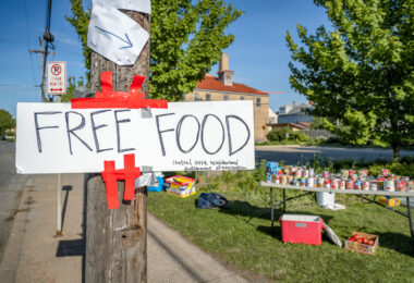 Sign that reads "FREE FOOD Central area neighborhood development organization". 

Food stands popped up after grocery stores were burned and other store damage following nights of riots in Minneapolis after the death of George Floyd.