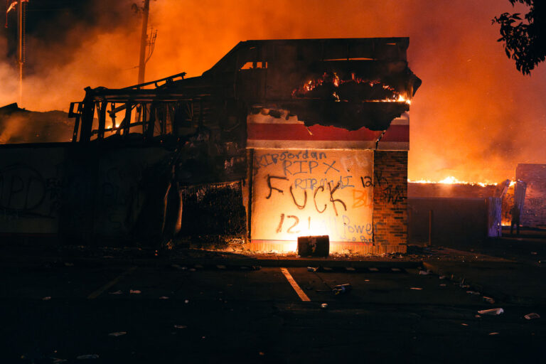 Fuck 12 written on a burning building 2 The Autozone across from the third precinct on fire. The retail store was the first substantial fire.