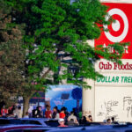 Protesters gather below a Target sign across from the Minneapolis Police third precinct.