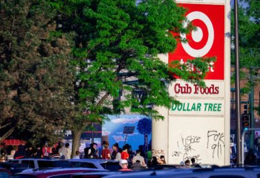 Protesters gather below a Target sign across from the Minneapolis Police third precinct.