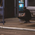 A man cleans glass up off the sidewalk from broken windows during the Minneapolis Uprising on May 30, 2020.