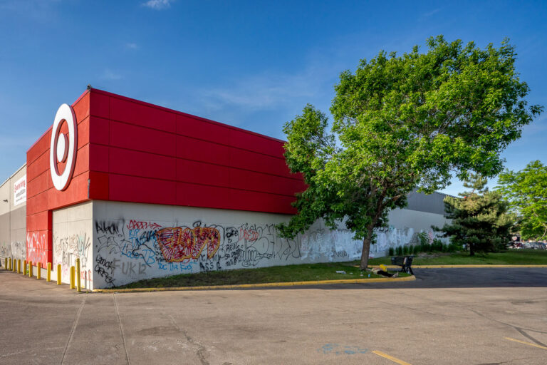 Target on Lake Street days after fire 4 A man lies on the grass outside of the Target Store on East Lake Street in South Minneapolis. Graffiti covered the store that sits across from the Minneapolis Police 3rd Precinct.