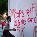 A man writes on a Target sign across from the Minneapolis police third precinct.