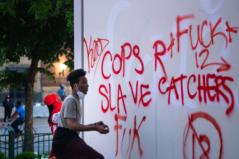 Minneapolis Police Third Precinct 4 A man writes on a Target sign across from the Minneapolis police third precinct.