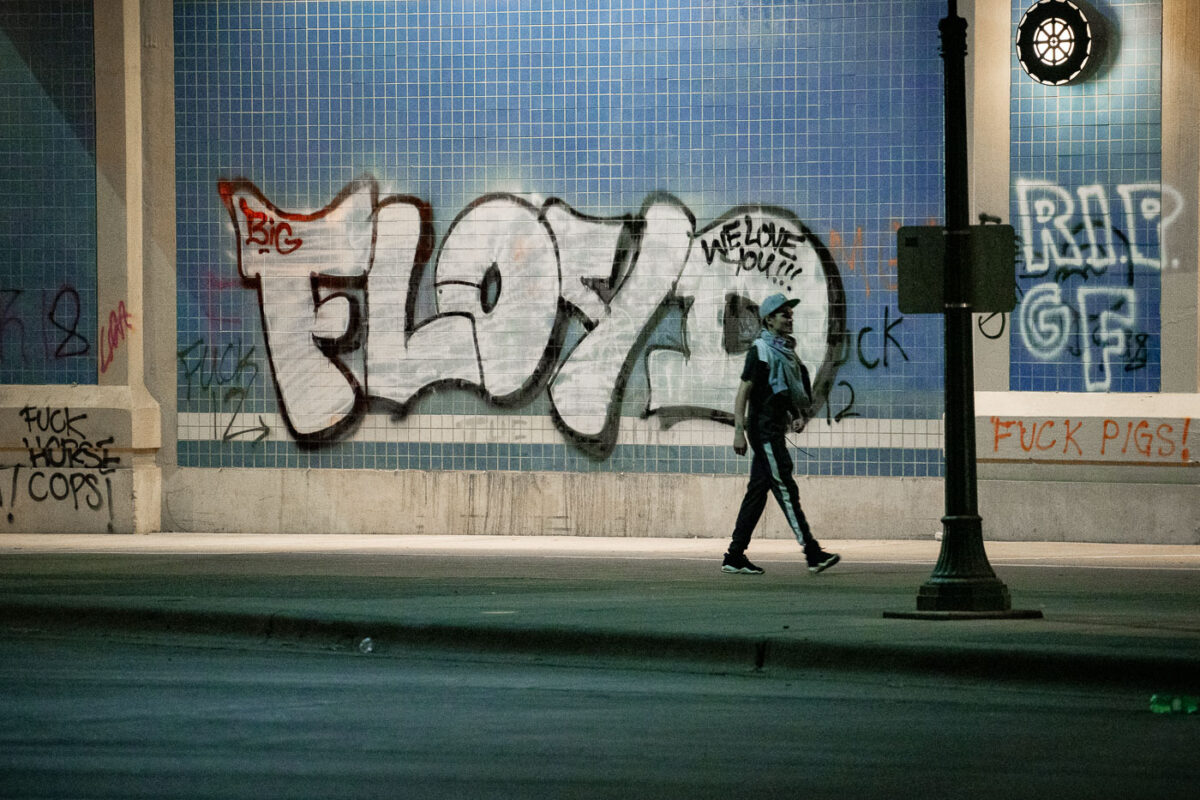 A protester waked under Haiwatha Ave where “FLOYD” is written on the wall. This on the 2nd day of protests in Minneapolis following the death of George Floyd.