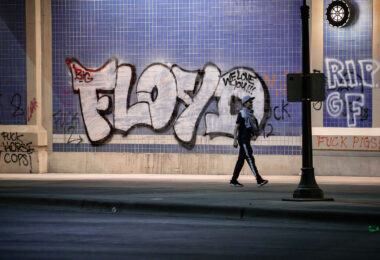 A protester waked under Haiwatha Ave where “FLOYD” is written on the wall. This on the 2nd day of protests in Minneapolis following the death of George Floyd.