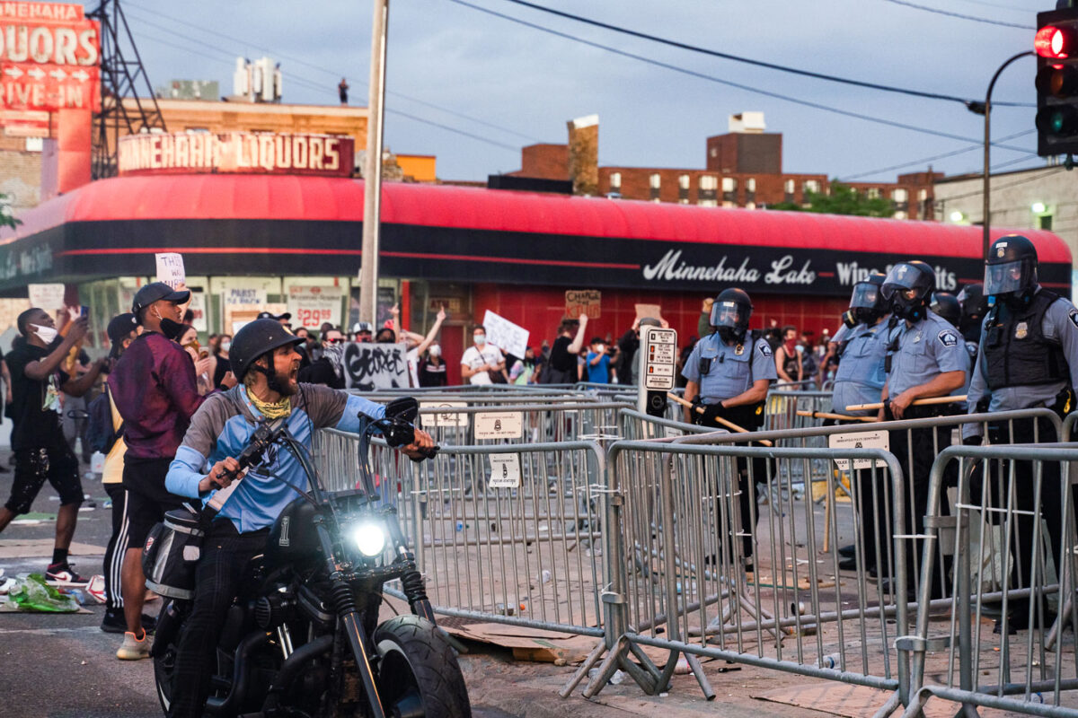 A man on a motorcycle yells at Minneapolis Police who are outside the 3rd Precinct as protesters continue to gather on the 2nd day of protests in Minneapolis following the death of George Floyd.