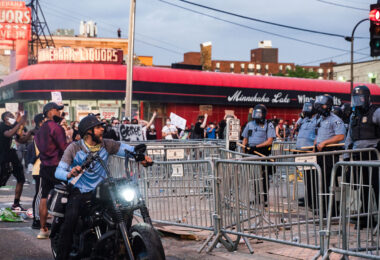 A man on a motorcycle yells at Minneapolis Police who are outside the 3rd Precinct as protesters continue to gather on the 2nd day of protests in Minneapolis following the death of George Floyd.