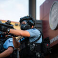 A Minneapolis Police officer aiming his less lethal weapon outside the Minneapolis Police 3rd Precinct on the second day of protests.