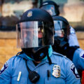 A Minneapolis police officer stands outside the third precinct on the second day of protests following the death of George Floyd.