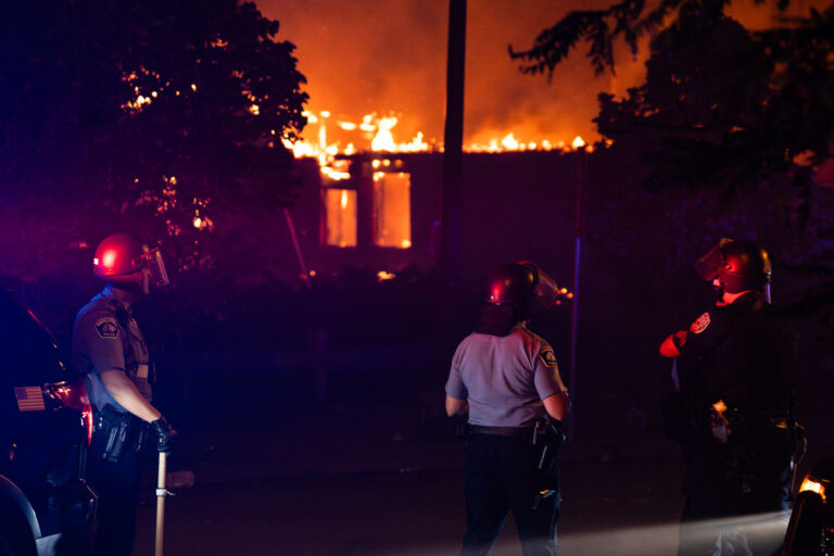 Minneapolis Police officer on Lake Street while fires burn 1 Minneapolis Police officer on Lake Street