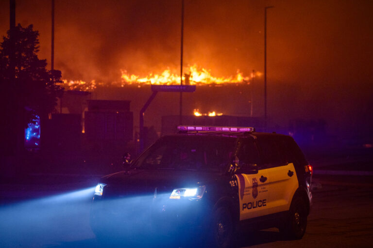 Minneapolis Police squad car during Minneapolis riots 4 A Minneapolis Police squad car while buildings burn behind it during the 2nd day of protests in Minneapolis following the death of George Floyd.