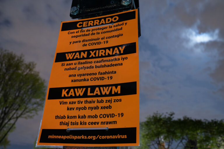 Multi language COVID signage in Minneapolis Park 1 Park closed due to coronavirus signage at Elliot Park in Minneapolis.