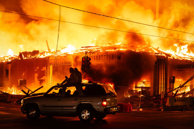Protester watched an under construction building burn 1 A 6-story new housing development on fire near the Minneapolis Police 3rd Precinct during the 2nd day of protests in Minneapolis following the death of George Floyd.