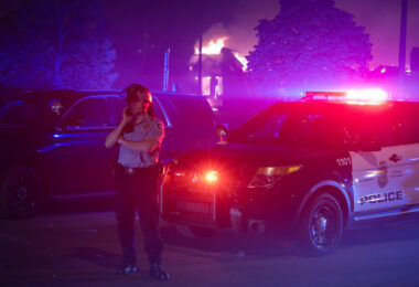 A Minneapolis Police officer outside of the burning AutoZone during the 2nd day of protests in Minneapolis following the death of George Floyd.