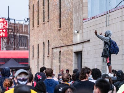 Proitester on top of squad car at Minneapolis police station